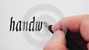 Handwritten word Handwriting. Male hand writing with a pen. Calligraphy closeup.