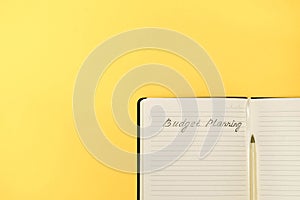 Handwritten words Budget Planning in a notepad on yellow background