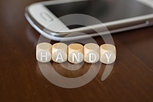 HANDY Blocks Beside A Smartphone