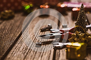 Handy Tools Christmas background concept. Pliers and wrenches with Christmas ornament decoration on a rustic wooden table