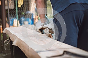 Handy woodcutter prepares larch wood for later processing. Planing wood. Working larch boards with traditional tools. Hand