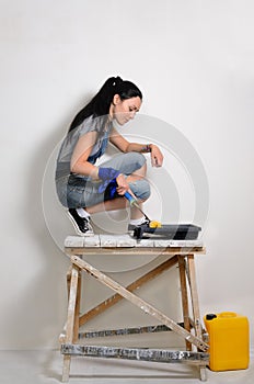 Handy young woman painting her hoause