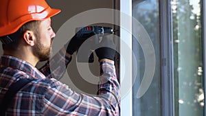 Handyman adjusting white pvc plastic window indoors
