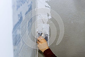 Handyman applying ceramic tiles on bathroom walls