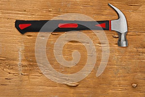 Handyman background with red and black hammer on distressed wood background