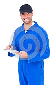 Handyman in blue overall writing on clipboard