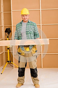 Handyman carpenter mature carry wooden beam