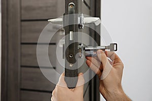 Handyman changing core of door lock, closeup