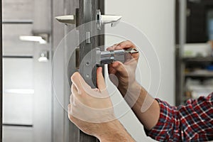 Handyman changing core of door lock indoors, closeup