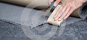 Handyman cutting a new carpet with a carpet cutter