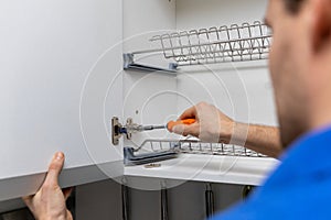 Handyman doing kitchen cabinet hinge adjustment