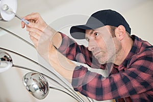 Handyman fixate lamp on ceiling