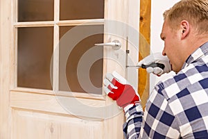 Handyman fixing the door with screwdriver photo