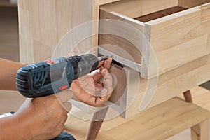 Handyman fixing over tight drawer slides rail of bedside table