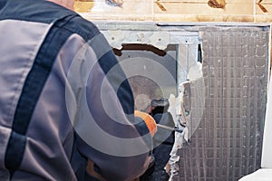 Handyman fixing a water pipe. Plumbing repair in a broken wall of a house