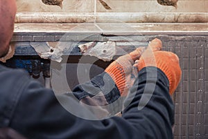 Handyman fixing a water pipe. Plumbing repair in a broken wall of a house