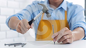 Handyman hammering a nail for House with siding panels, construction work and renovation service