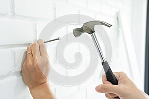 Handyman hammering a nail for House with siding panels, construction work and renovation service