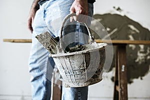 Handyman holding basket cement for construction