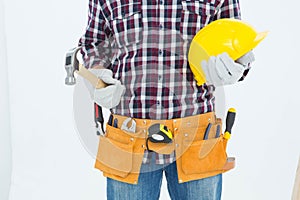 Handyman holding hard hat and hammer