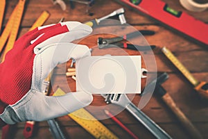 Handyman and home repair services - hand holding blank business card over the work tools