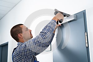 Handyman Installing And Fixing Door Closer photo