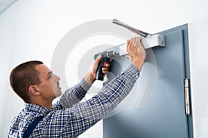 Handyman Installing And Fixing Door Closer photo