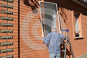 Handyman installing mosquito net screen on house window