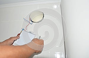 Handyman installing new bath vent fan, ventilation system in the house bathroom. Bath fan repair, installation