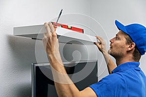 Handyman installing shelf on the wall