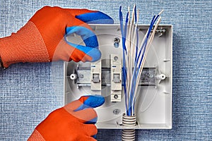 A handyman installs the fuse box in home wiring