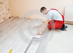 Handyman laying down laminate flooring boards