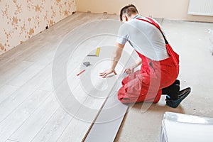 Handyman laying down laminate flooring boards