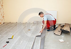 Handyman laying down laminate flooring boards