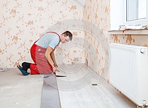 Handyman laying down laminate flooring boards