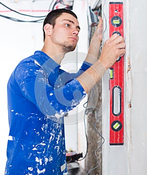 Handyman measuring angle of wall with level