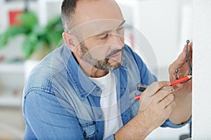 handyman mounting hook on wall