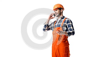Handyman in orange overall and helmet talking on the phone
