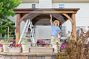 Handyman painting a newly installed wooden gazebo