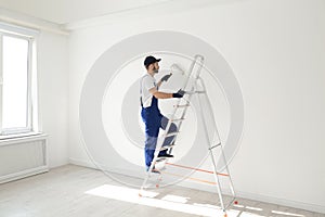 Handyman painting wall with roller brush. Professional construction tools