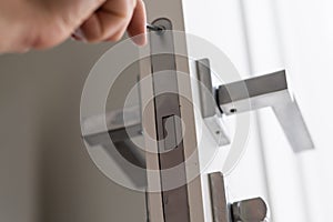 A handyman repair the door lock in the room. The concept repair yourself. Selective focus