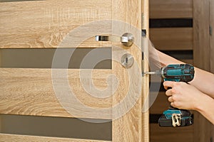 Handyman repair the door lock in the room. man repairing the door handle furniture. carpenter at lock installation with