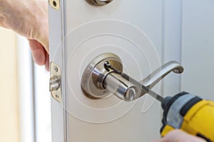 handyman repair the door lock in worker& x27;s hands installing new door locker