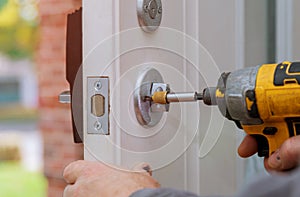 handyman repair the door lock in worker& x27;s hands installing new door locker