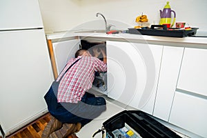 Handyman repair pipes on sink in the kitchen