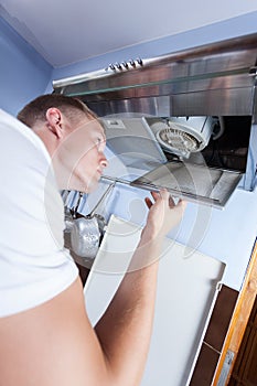 Handyman repairing kitchen extractor fan