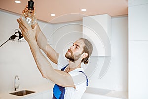 Handyman replacing lightbulb at home