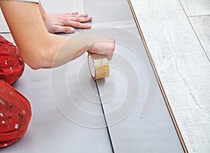 Handyman`s hands laying down laminate flooring boards