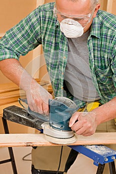 Handyman sanding wooden board diy home renovation