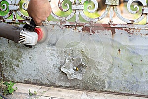 Handyman scrape the old paint from rusty fence